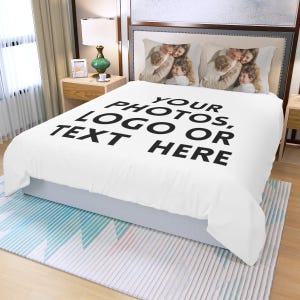 Könnte beinhalten: Eine weiße Bettdecke mit dem Text "YOUR PHOTOS, LOGO OR TEXT HERE" in großen schwarzen Buchstaben. Zwei Kissenbezüge mit einem Familienfoto sind auf dem Bett. Das Bett ist gemacht und einsatzbereit.