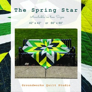 May include: A quilt pattern called "The Spring Star" is available in two sizes: 42 inches by 42 inches or 60 inches by 60 inches. The quilt is made with green, yellow, and black fabric and features a star design. The quilt is displayed on a bench in a park setting.