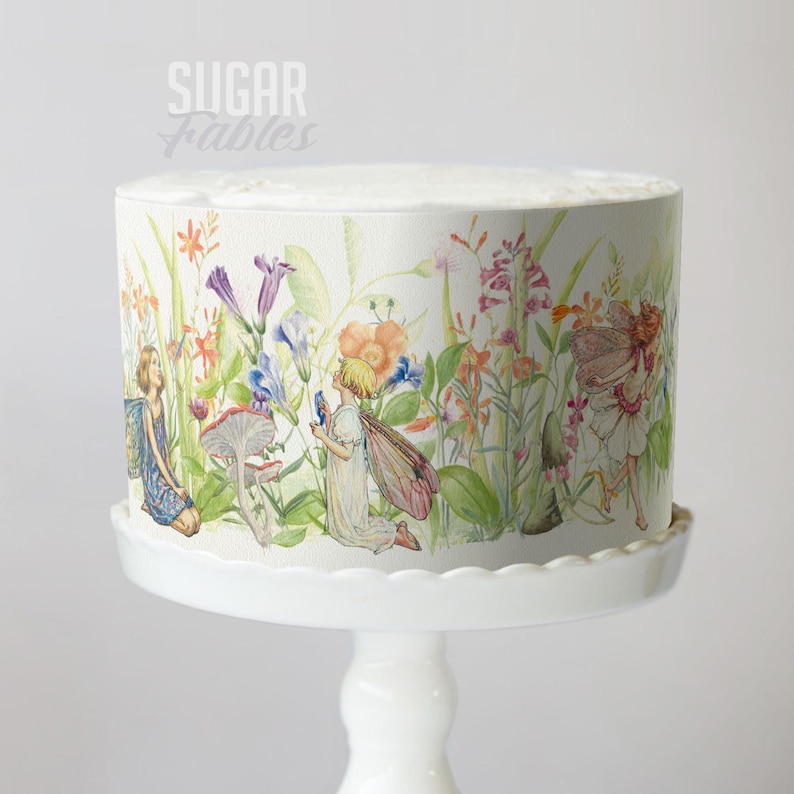 A cake decorated with a whimsical, fairy-themed design featuring colorful flowers, fairies, and other fantastical elements.