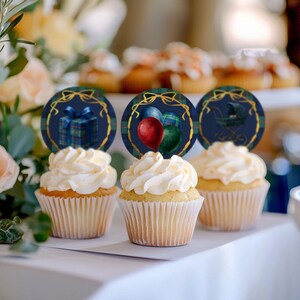 Puede incluir: Tres cupcakes con glaseado blanco y adornos decorativos. Los adornos son redondos con un fondo azul marino y detalles dorados. Los adornos presentan un regalo, globos y un cochecito de beb&eacute;.