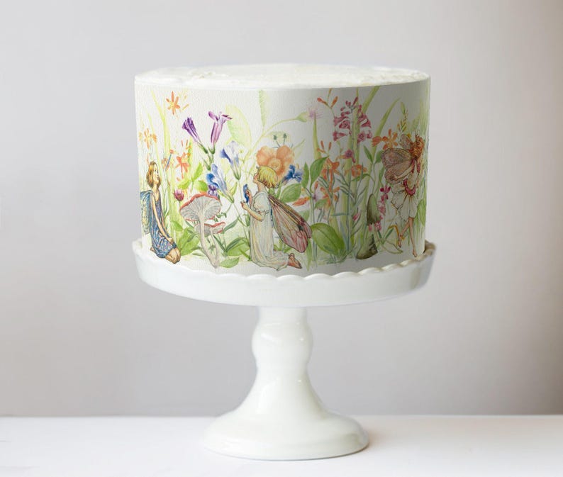 edible cake wrap features a delicate, hand-painted botanical illustration with fairies nestled among lush flowers, leaves, and mushrooms. The intricate artwork includes pastel tones with vibrant floral accents, evoking a whimsical, storybook-inspired aesthetic.