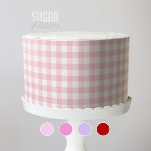 May include: A round cake with a pink and white gingham pattern, displayed on a white cake stand. The cake is decorated with the text "Sugar Fables" in a script font. Four colour swatches are shown below the cake.