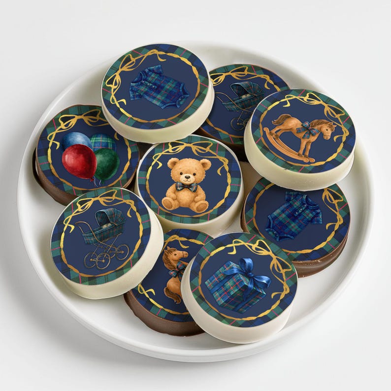 Puede incluir: Un plato blanco contiene varios bombones redondos. Cada bomb&oacute;n presenta un centro azul marino con un dise&ntilde;o de cinta dorada y un gr&aacute;fico tem&aacute;tico de beb&eacute;, como un oso de peluche, globos o un caballito balanc&iacute;n. Los bordes tienen un patr&oacute;n de cuadros.