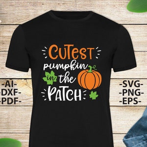 May include: A black short-sleeved t-shirt featuring the orange and white text "CUTEST pumpkin in the PATCH" with a graphic of an orange pumpkin and green leaves. The text "AI-DXF-PDF" and "SVG-PNG-EPS" is printed on the sides of the shirt.