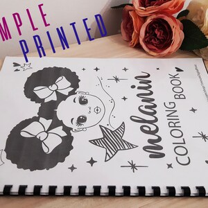 Op de afbeelding: Een zwart-wit kleurboek met een omslag waarop een meisje met krullend haar en een strik te zien is. De titel van het boek is "melanin coloring book".