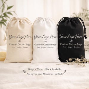 May include: Three custom cotton drawstring bags in beige, white, and black. Each bag features the text "Your Logo Here" above "Custom Cotton Bags" and "Text &bull; Logo &bull; Design". The bags are displayed on a white surface.