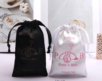 May include: Two drawstring bags, one black and one white, with a pink peace sign logo and the text "Potir'e Box" and "Vibrate High". The bags are 10 by 15 centimeters.