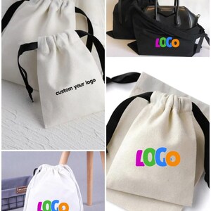 May include: Four white cotton drawstring bags with black drawstrings. The bags are shown in different positions and have different text printed on them. One bag says "custom your logo", another says "LOGO" in colorful letters, and another says "LOGO" in white letters.