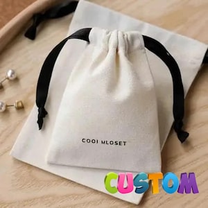 Op de afbeelding: Een witte keramische mok met een zwart handvat en de tekst "But First, Coffee" in een vetgedrukte, zwarte letter. De mok staat tegen een neutrale achtergrond, wat het eenvoudige ontwerp benadrukt.