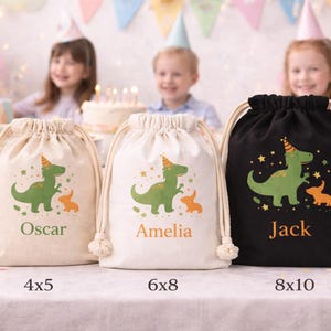 May include: Three drawstring party favor bags in beige, white, and black. Each bag features a green dinosaur and orange animal graphic, with names Oscar, Amelia, and Jack. Sizes are 4x5, 6x8, and 8x10 inches.