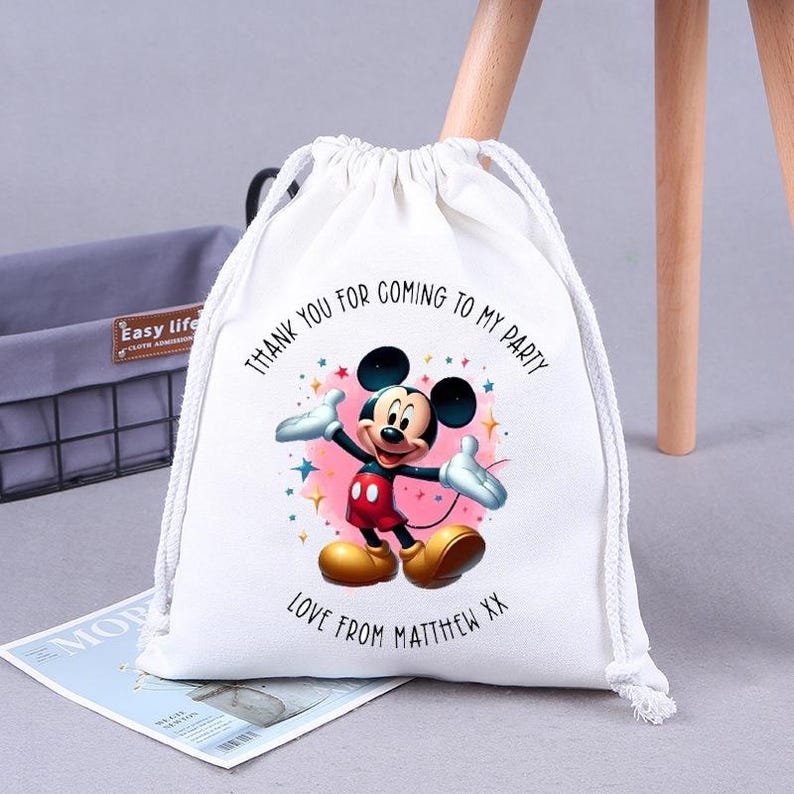 May include: White drawstring bag with a Mickey Mouse design. The bag has the text "Thank you for coming to my party" and "Love from Matthew XX".