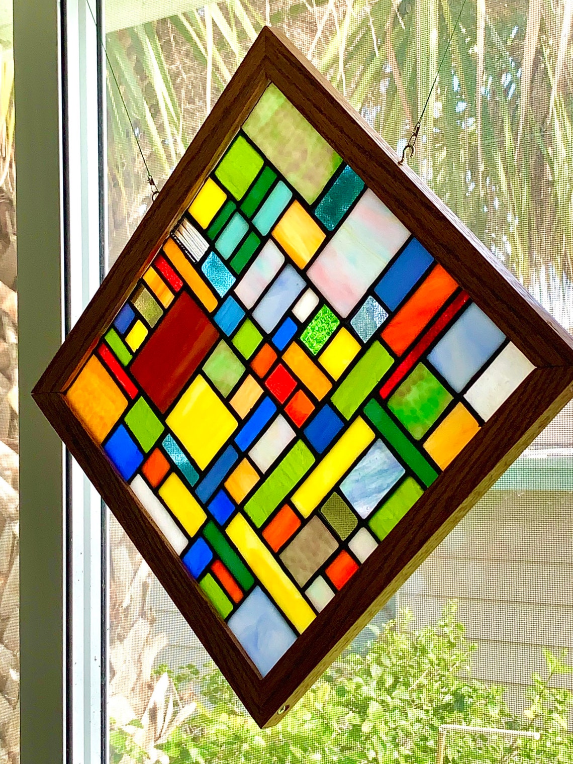 Stained glass panel mounted in custom red oak wood frame. Etsy