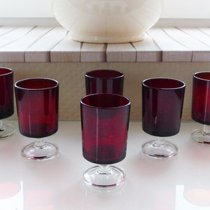 Puede incluir: Juego de seis vasos de bebida de tallo rojo rubí con bases de vidrio transparente.