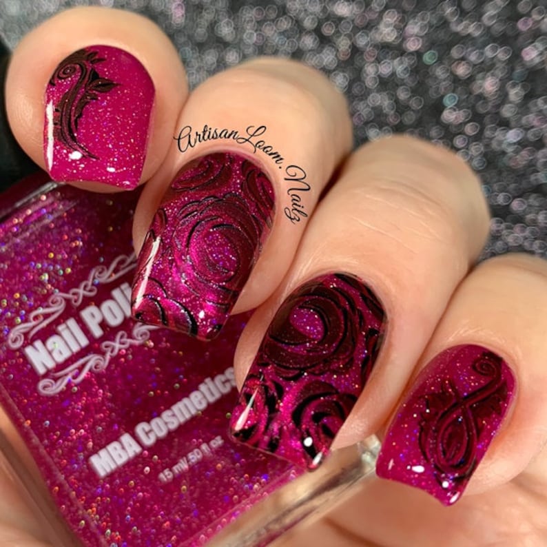 Pu&ograve; includere: Primo piano di una mano con smalto per unghie glitter rosa e nail art a spirale nera. La bottiglia di smalto per unghie &egrave; etichettata "Nail Polish" e "MBA Cosmetics". Il testo "Artisan Loom Nails" &egrave; scritto sulla mano.