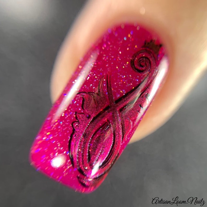 Pu&ograve; includere: Primo piano di un'unghia rosa con un design a spirale nero. Lo smalto ha una finitura glitter.