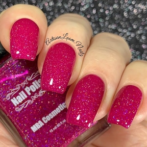 Pu&ograve; includere: Un flacone di vetro trasparente di smalto per unghie glitter rosa con il testo "Nail Polish" e "MBA Cosmetic" sull'etichetta. Il flacone &egrave; da 15 ml / 0,5 fl oz. L'immagine mostra una mano con quattro dita dipinte con lo smalto per unghie glitter rosa.
