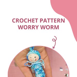 May include: A crocheted worry worm with a blue and white striped body and a wooden head with a smiling face. The worm is being held in a hand.