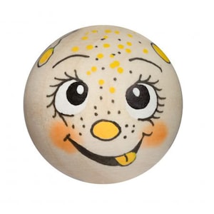 May include: A wooden ball with a painted face. The face has yellow dots, black eyes, a yellow nose, and a black smile with a yellow tongue sticking out.
