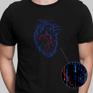 Op de afbeelding: Een zwart T-shirt met een afbeelding van een menselijk hart gemaakt van blauwe en rode binaire code.