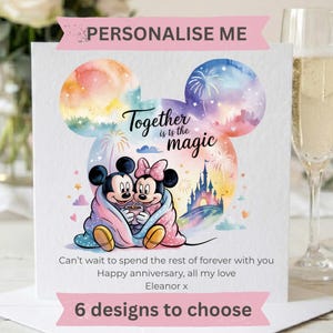 May include: A square greeting card featuring a watercolor Mickey and Minnie Mouse wrapped in a blanket under a castle and fireworks. Text reads: PERSONALISE ME, Together is the magic, Can't wait to spend the rest of forever with you, Happy anniversary, all my love, Eleanor x, 6 designs to choose.