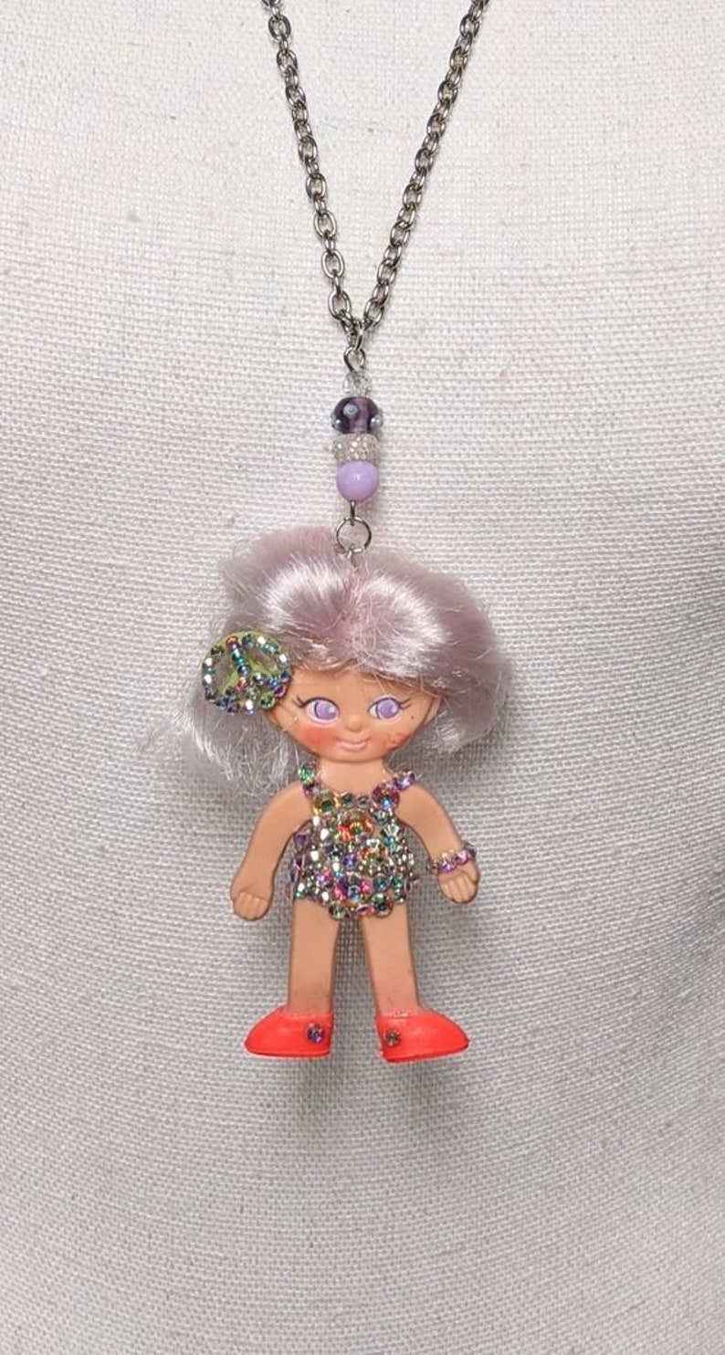 Vintage Flatsy doll. These minis have been turned into very unique, retro looking necklaces.Truly a oneofakind piece of fun kitschy jewelry. 