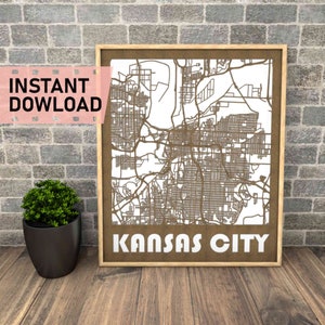 Könnte beinhalten: Ein brauner Holzrahmen mit weißem Hintergrund und einer detaillierten Karte von Kansas City, Missouri. Der Text "KANSAS CITY" ist unten im Rahmen in Weiß gedruckt.