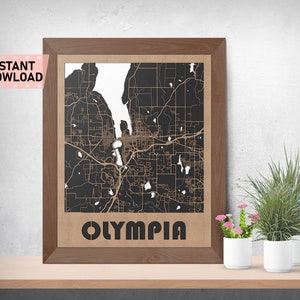 May include: A framed map of Olympia, Washington, with a black background and brown lines depicting streets and waterways. The city name is printed in brown letters at the bottom of the map.