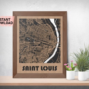 May include: A framed print of a black and white map of Saint Louis, Missouri. The map is printed on brown paper and has a brown wooden frame.