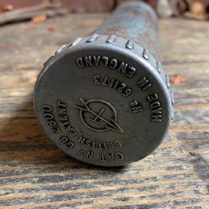 May include: A silver metal grease gun with a black cap. The cap has the text "CAT. NO. 62113 MADE IN ENGLAND" and "BRITISH PATENT GB 2800".