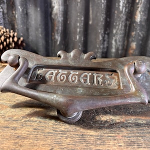 May include: Antique brass letter plate with a decorative design and a handle. The plate has the word "Letters" engraved on it.