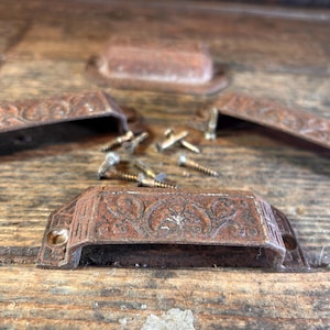 May include: A white ceramic mug with a black handle and the text "But First, Coffee" in a handwritten style. The mug is on a white surface. The mug is approximately 4 inches tall.