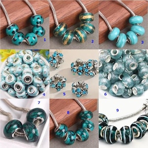 May include: A collection of beads in various designs and colors. Some beads are teal with black spots, others have gold accents, and some are solid teal. There are also silver-toned beads with blue gemstones and a pile of glittery teal beads.