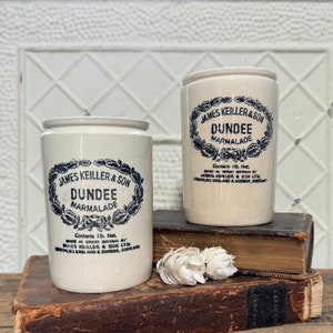 May include: Two vintage ceramic jars with blue and white labels that read "James Keiller & Son Dundee Marmalade" and "Contents 1 lb. Net. Made in Great Britain by James Keiller & Son Ltd. London, England & Dundee, Scotland".