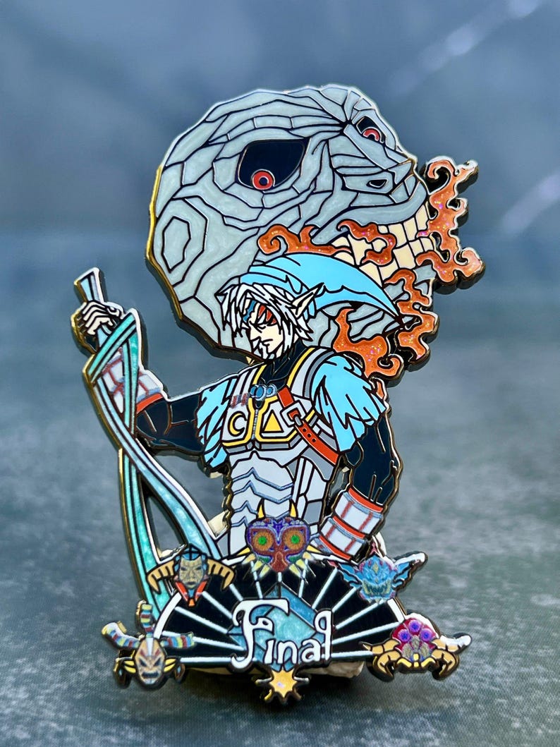 May include: A detailed enamel pin featuring a character with a blue hat and sword, set against a background of a skull and flames. The pin has a black, blue, white, and orange color scheme, with the word "Final" at the bottom.