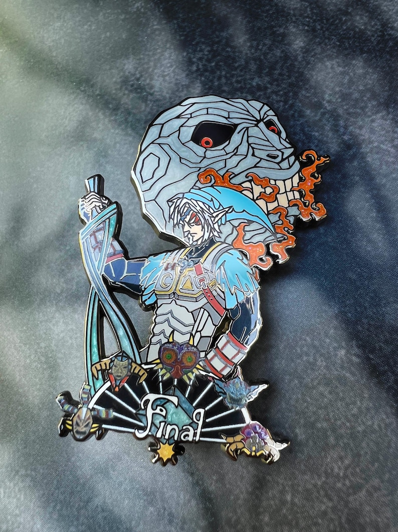 May include: Enamel pin featuring a character from a video game, with a blue and white color scheme. The pin includes a character holding a sword, a skull, and the word "Final".