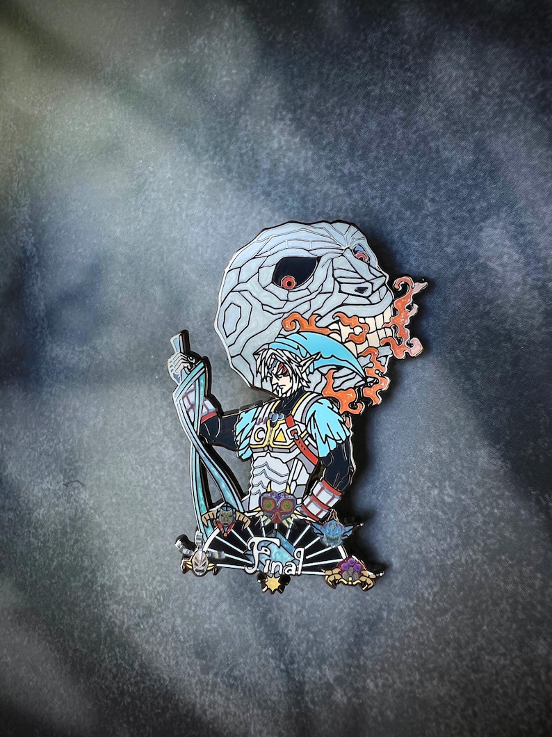 May include: Enamel pin featuring a character with a blue cap and tunic, holding a sword, with a skull-like mask behind him. The pin has a black, white, blue, orange, and gold color scheme. The word "Final" is written on the bottom.