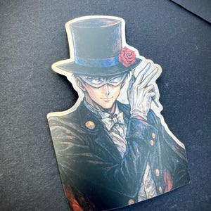 May include: A sticker featuring a detailed illustration of a person in a black top hat with a red rose, white gloves, and a mask. The person is wearing a black suit with a white bow tie, and is holding a magic wand.