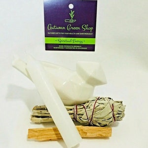 May include: White ceramic bird figurine with a white candle and a bundle of sage smudge sticks. The sage is tied with red string. The label reads "Autumn Green Shop" and "Spiritual Energy".