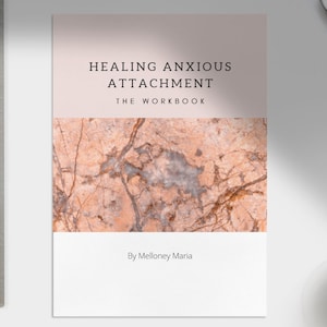 Op de afbeelding: Een roze en witte boekomslag met de titel "Healing Anxious Attachment The Workbook" en de auteur "By Mellonay Maria". De achtergrondafbeelding is een marmerpatroon met bruine en witte aderen.