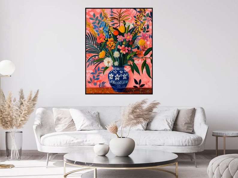 May include: A blue and white porcelain vase filled with a colorful bouquet of flowers, including pink, red, yellow, and orange blooms. The vase is sitting on a wooden table against a pink background.