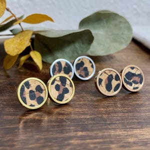 Könnte beinhalten: Drei Paar Ohrringe aus Kork mit Leopardenmuster in Gold, Silber und Roségold.