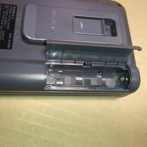 May include: A black Sony cassette player with the text "SONY&reg; CASSETTE PLAYER WM-EX190" and "BATTERY SUPPLY 1.5V&times;2 IEC, JIS R6 SIZE AA OR EQUIV. SONY CORP MADE IN CHINA 3-342-254-01" printed on the side. The cassette player has a battery compartment that is open and empty.