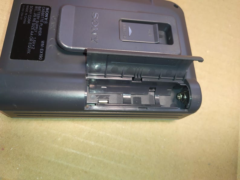 May include: A black Sony cassette player with the text "SONY&reg; CASSETTE PLAYER WM-EX190" and "BATTERY SUPPLY 1.5V&times;2 IEC, JIS R6 SIZE AA OR EQUIV. SONY CORP MADE IN CHINA 3-342-254-01" printed on the side. The cassette player has a battery compartment that is open and empty.