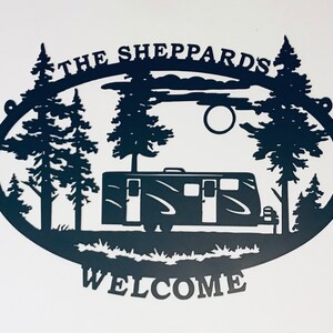 May include: Black metal silhouette of a camper van parked in a forest with trees and a full moon. The text "The Sheppards" is above the scene and "Welcome" is below.