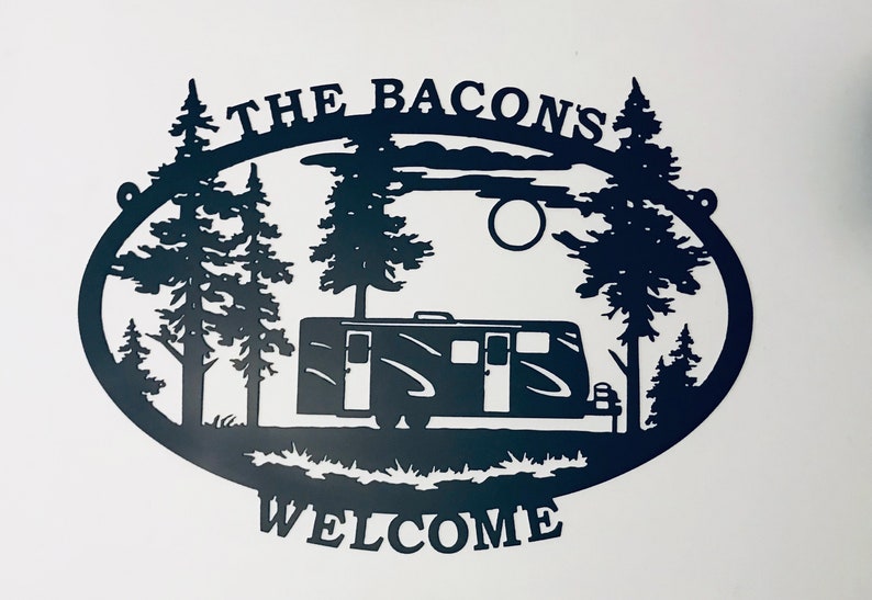 May include: Black metal silhouette of a camper van in a woodland setting with the text "The Bacons Welcome" above the camper.