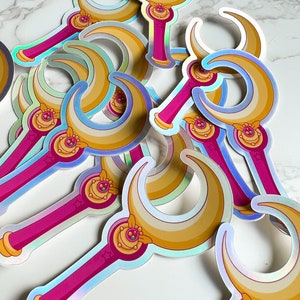 Close up of moon stick wand sticker, showing the vibrant rainbow colors from the holographic effect of the vinyl decal.