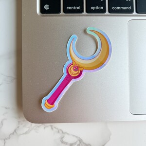 Holographic Moon stick wand sticker on top of a laptop. This sticker is the ideal size for laptops and water bottles.
