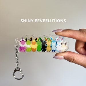 Shiny Eeveelutions clear acrylic keychain featuring shiny versions of the Eevee evolutions: Flareon, Jolteon, Vaporeon, Umbreon, Espeon, Leafeon, Glaceon, and Sylveon.