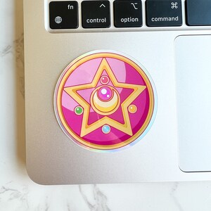 Sailor moon crystal star brooch sticker on top of a laptop. Durable vinyl Sailor Moon sticker for laptops and water bottles.