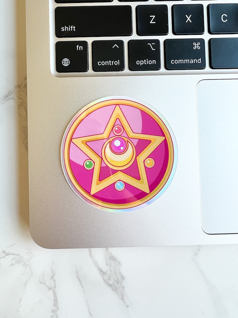 Sailor moon crystal star brooch sticker on top of a laptop. Durable vinyl Sailor Moon sticker for laptops and water bottles.